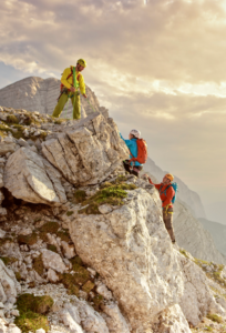 group of people in white long sleeve shirt and green pants standing on rocky ground